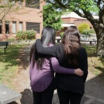 Two women hold each other.