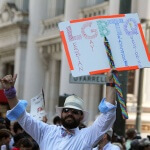 A supporter of LGBTQ rights holding a sign at a rally.